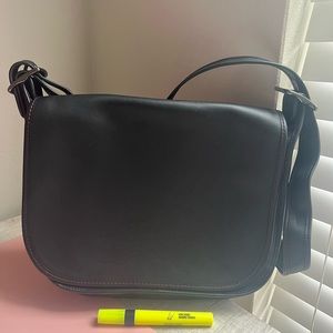 Black leather Coach purse with burgundy inside and adjustable cross body strap.